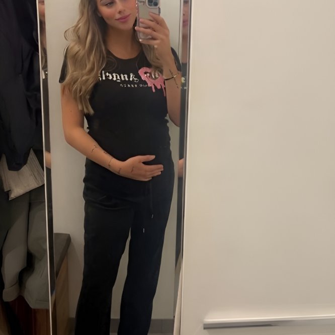 Man sieht mich im Spiegel ein Selfie machen, meine Hand liegt auf dem Babybauch.